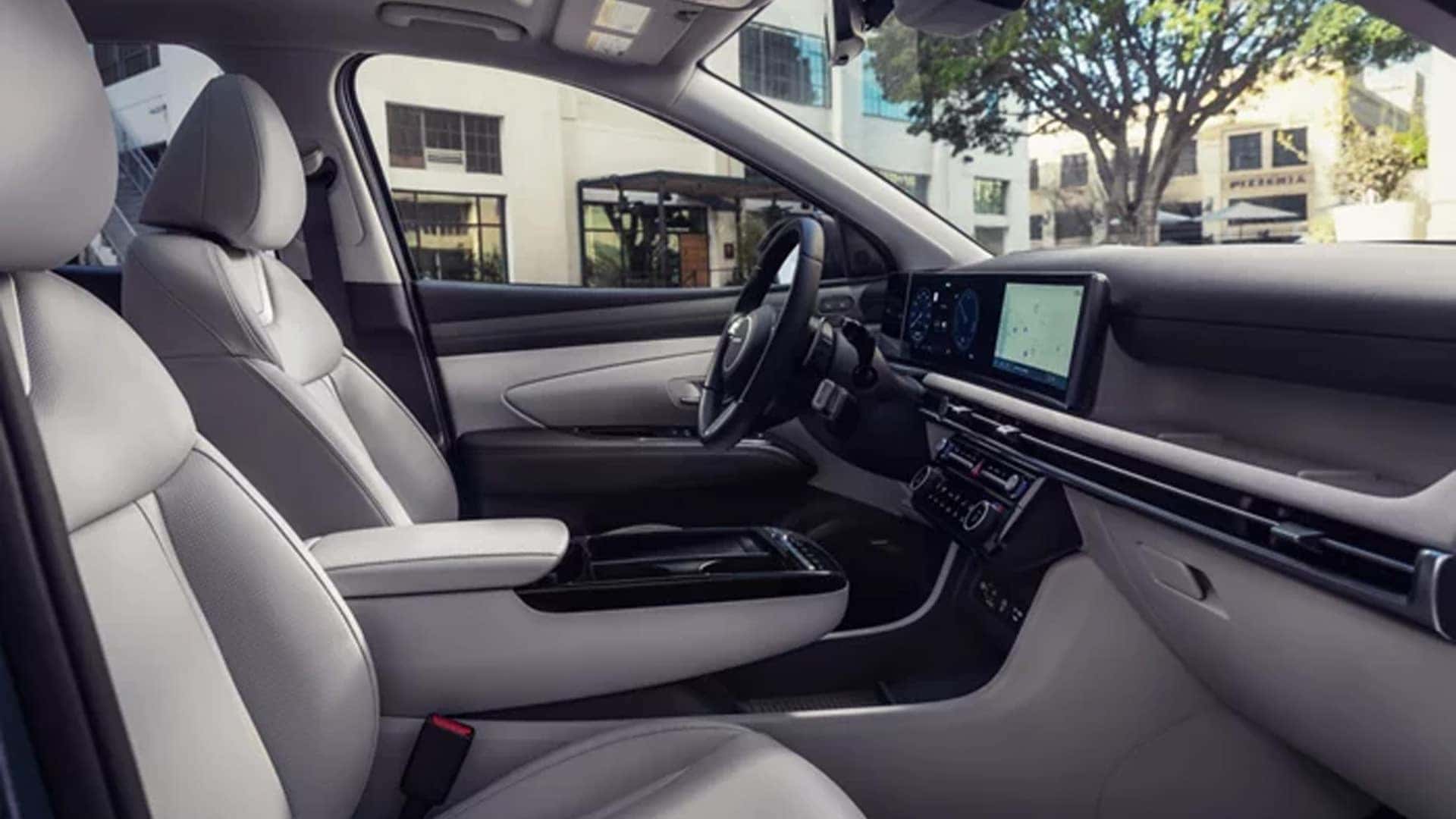 Interior of the Hyundai Tucson Hybrid with light-colored seats, spacious front cabin, and a modern dashboard layout.