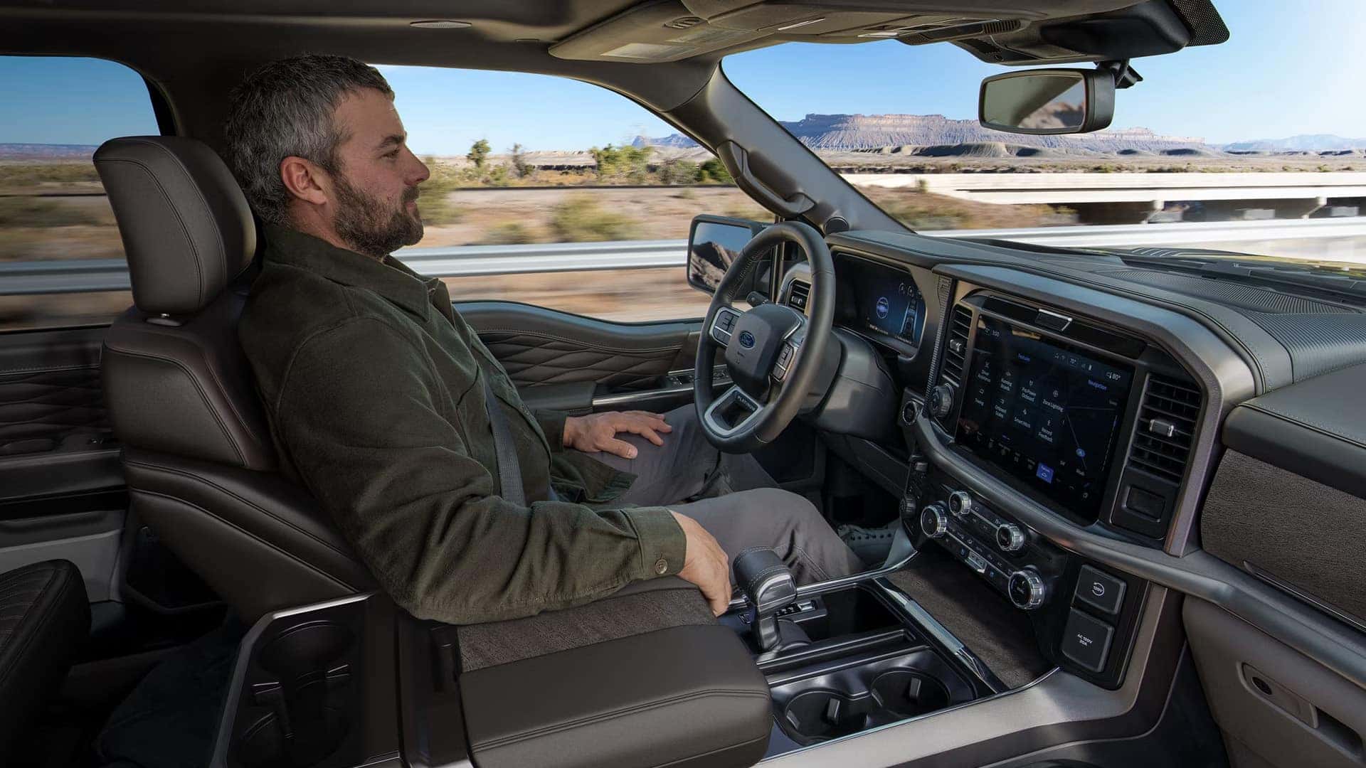 Driver using available BlueCruise hands-free highway driving in a 2026 Ford F-150 with system status shown on the dashboard display