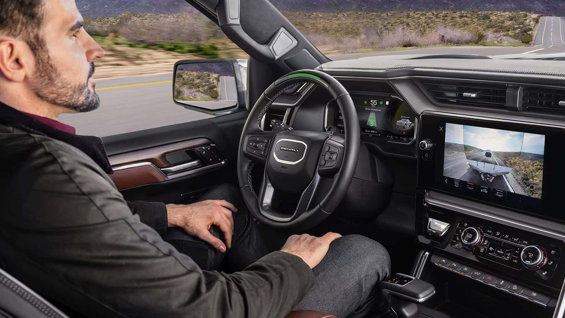 Driver seated in the 2026 GMC Sierra 1500 with available Super Cruise hands-free driver assistance active and camera view displayed on the center screen.