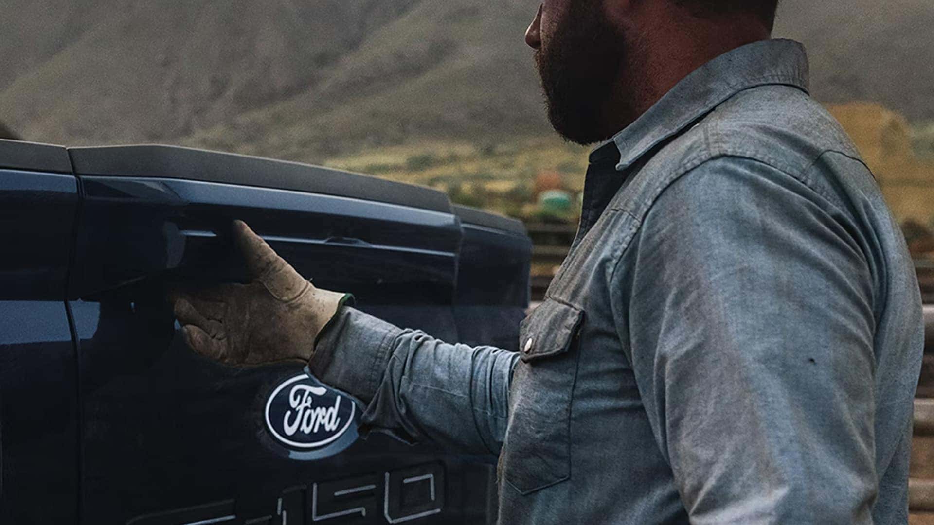 Person opening the Pro Access Tailgate on a 2026 Ford F-150, demonstrating improved cargo bed access and tailgate functionality.