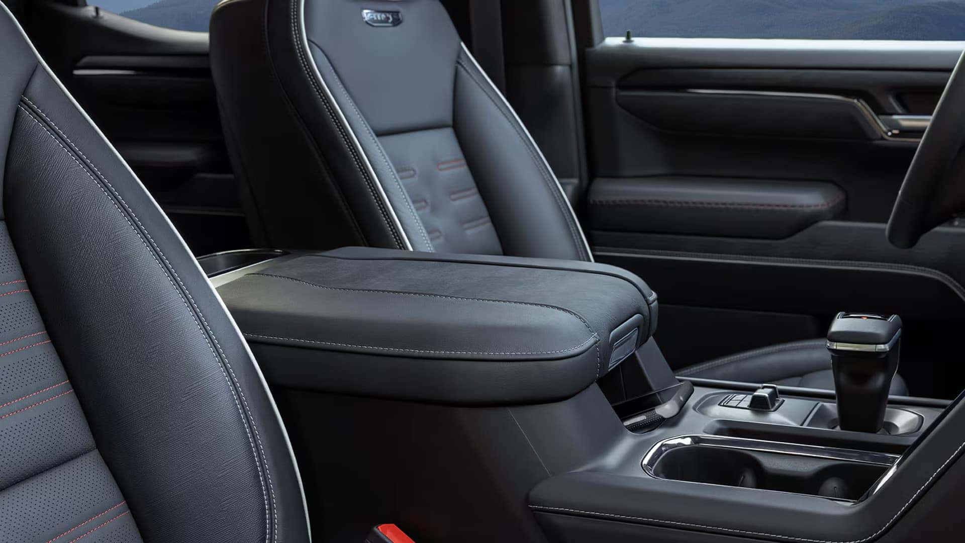 2026 GMC Sierra 1500 center console with armrest storage, gear selector, and cup holders