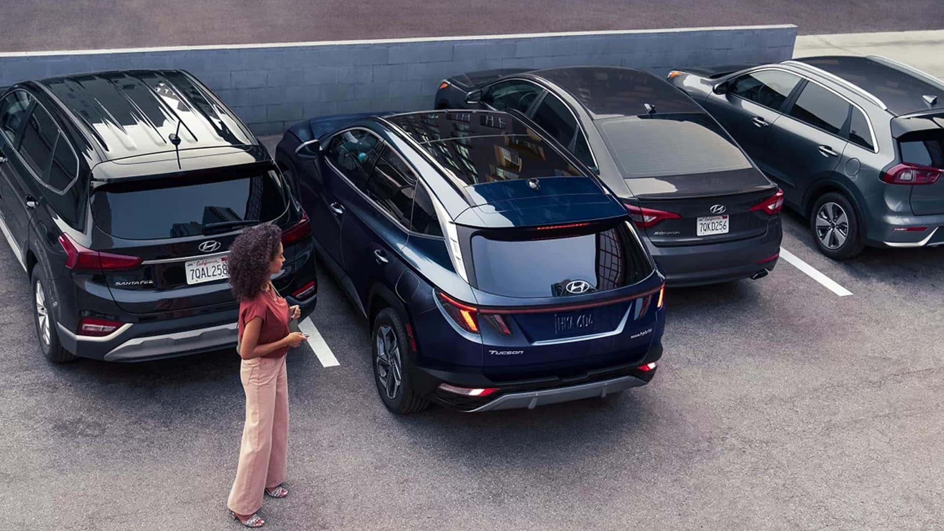 Overhead view of multiple Hyundai Tucson Hybrid SUVs parked in a lot, emphasizing roof design and compact SUV dimensions.