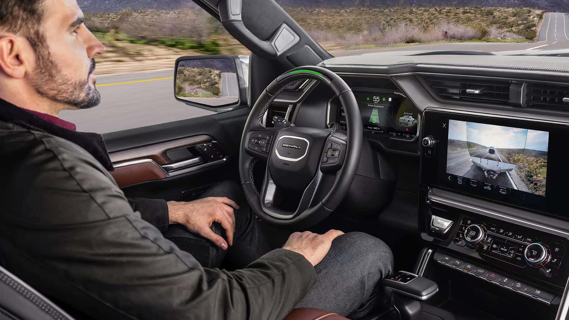 Driver using hands-free driving technology inside the GMC Sierra 1500, with digital displays and advanced safety features visible.