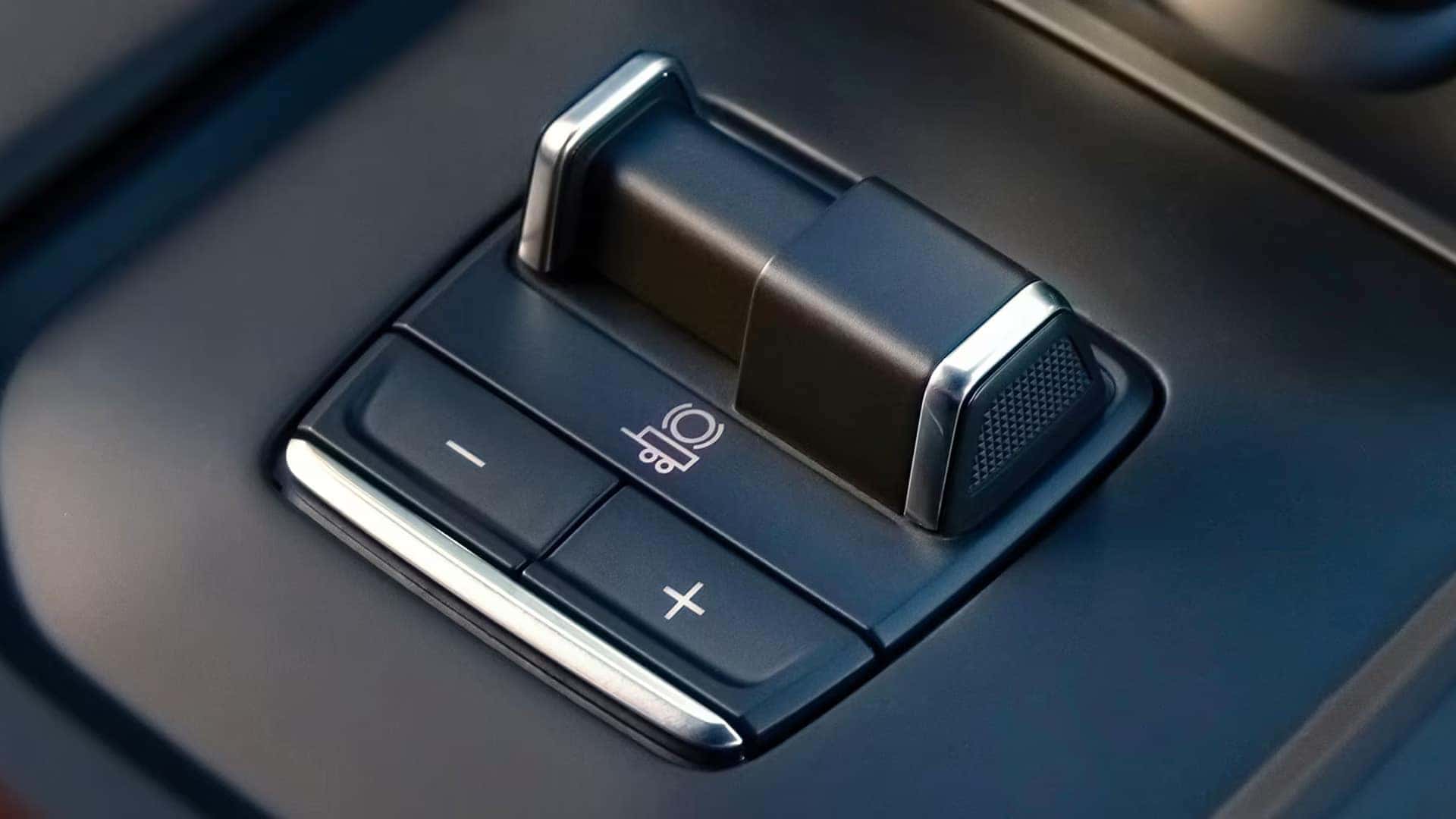 Close-up of the Sierra 1500 integrated trailer brake controller with plus and minus buttons on the dash panel.