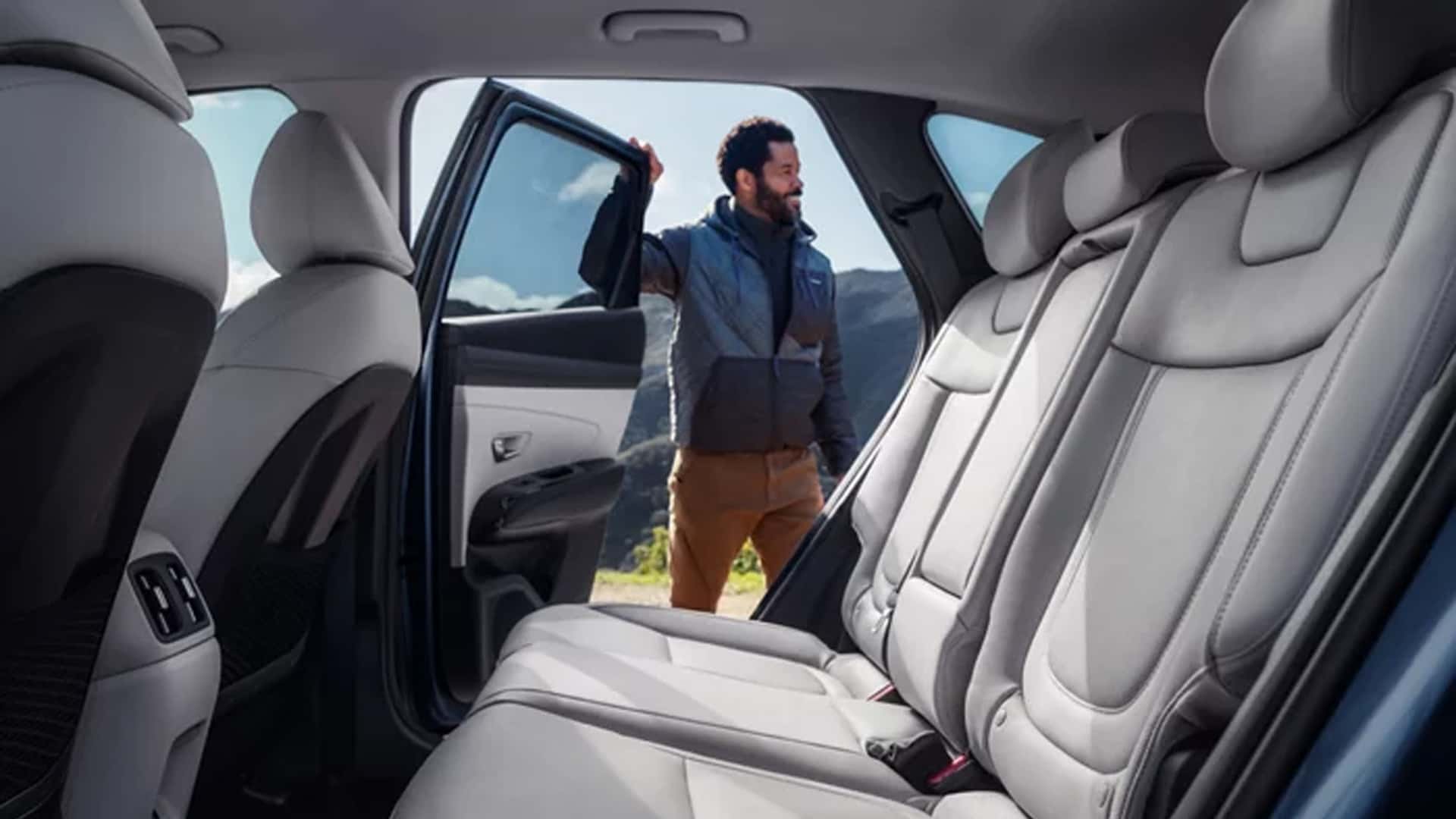 Rear seating area of the Hyundai Tucson Hybrid with ample legroom and comfortable seating for passengers.