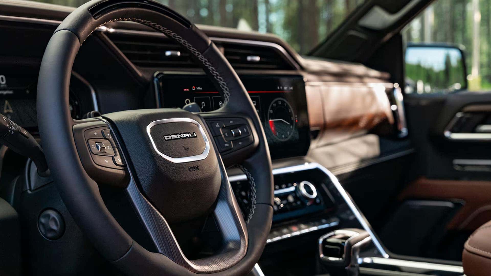 Interior view of the 2026 GMC Sierra 1500 Denali showing the steering wheel, premium materials, center console controls, and refined cabin design.