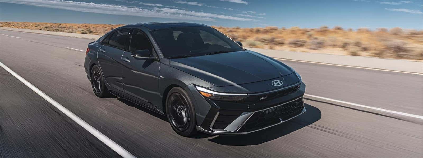 2026 Hyundai Elantra sedan driving on an open road, showcasing modern exterior styling