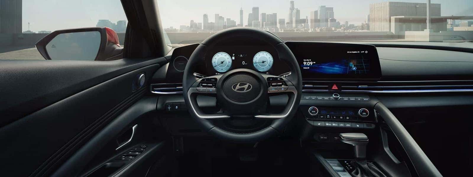 2026 Hyundai Elantra interior showing a digital instrument cluster, wide center touchscreen, steering wheel controls, and modern dashboard layout