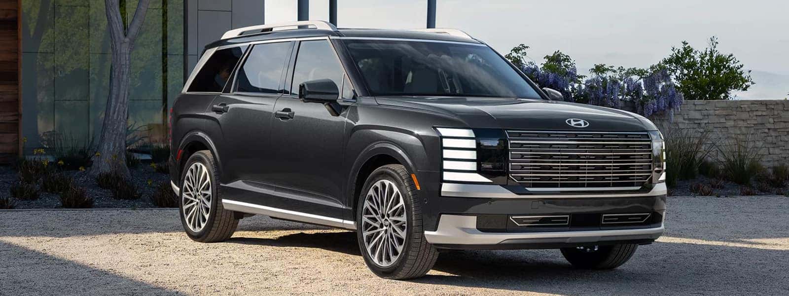 2026 Hyundai Palisade Hybrid SUV shown from a front three quarter angle with bold grille design, LED lighting, and a premium three row exterior stance
