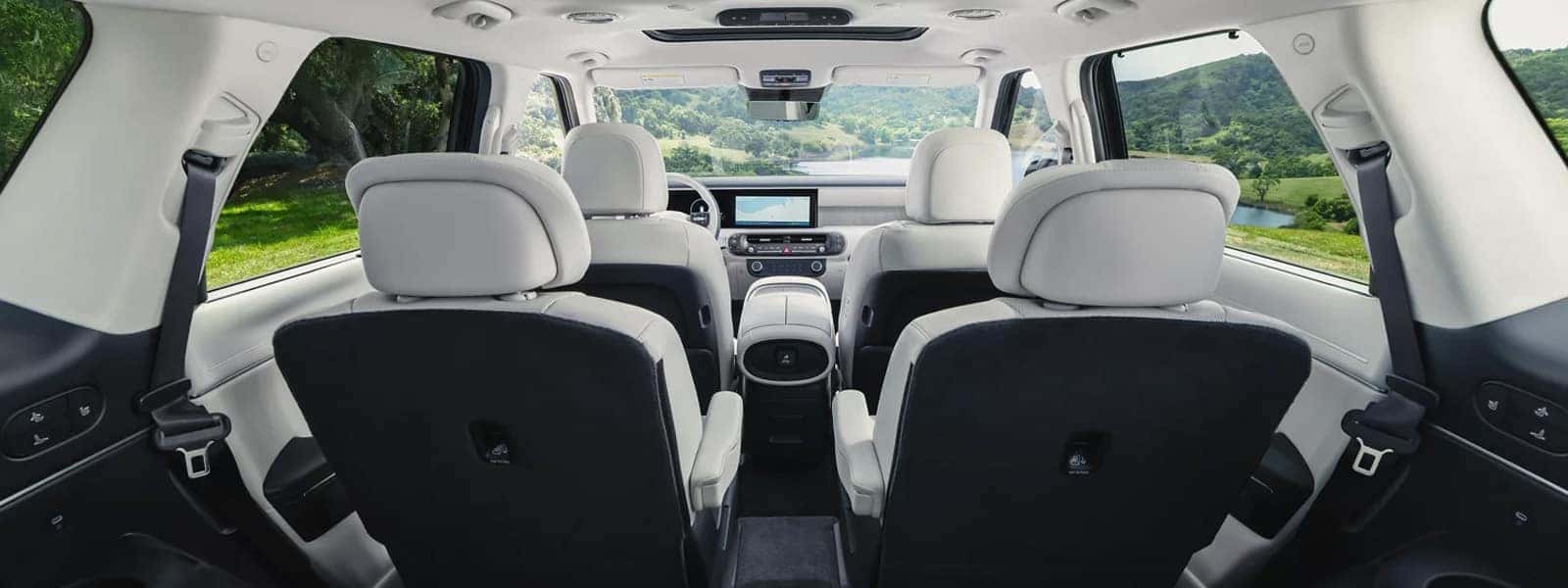 2026 Hyundai Palisade Hybrid interior showing a wide three row cabin with light upholstery, panoramic roof, and modern dashboard layout