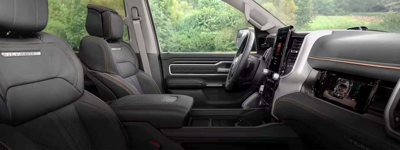 2026 Ram 1500 interior showing the driver cockpit with a large center touchscreen, digital instrument cluster, premium materials, and center console storage