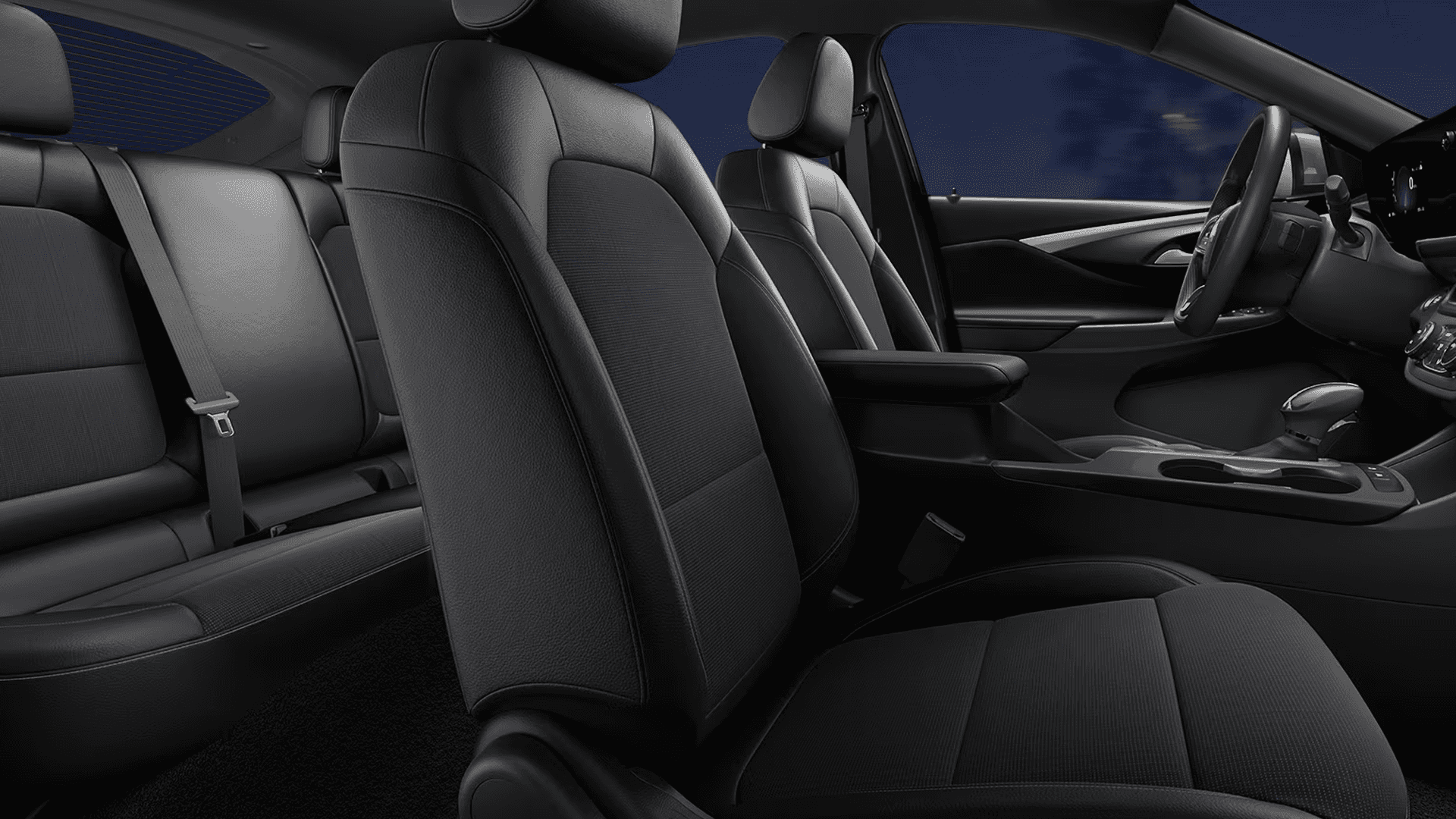 Wide interior cabin view of the 2026 Buick Envista showing front seats, rear bench seating, center console with cupholders and shifter, and the dashboard layout from the passenger side perspective