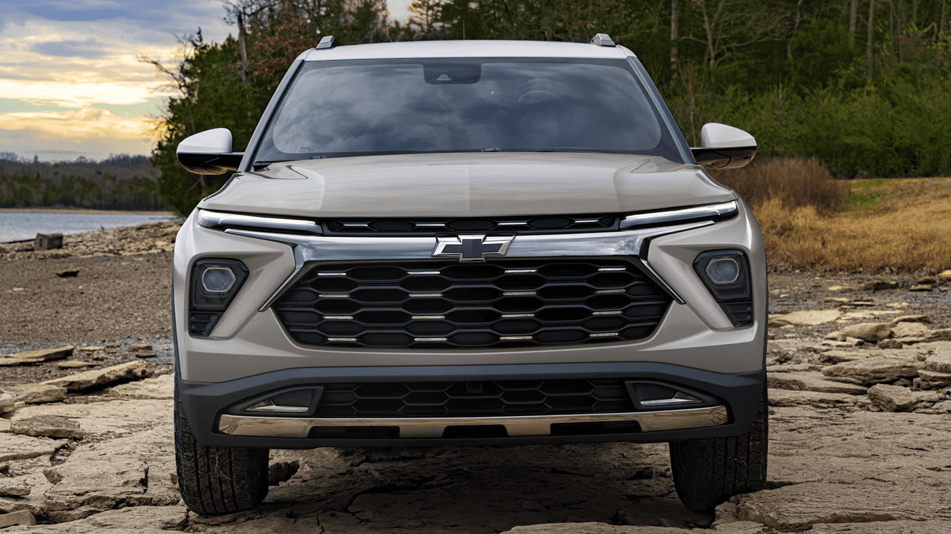 Front view of a light tan Chevy Trailblazer showing the wide grille design, Chevrolet bowtie emblem, and upper lighting strip.