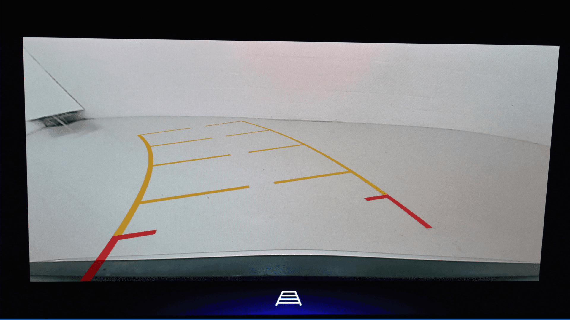 Rear vision camera display showing curved parking guidelines and distance markers while backing into a space