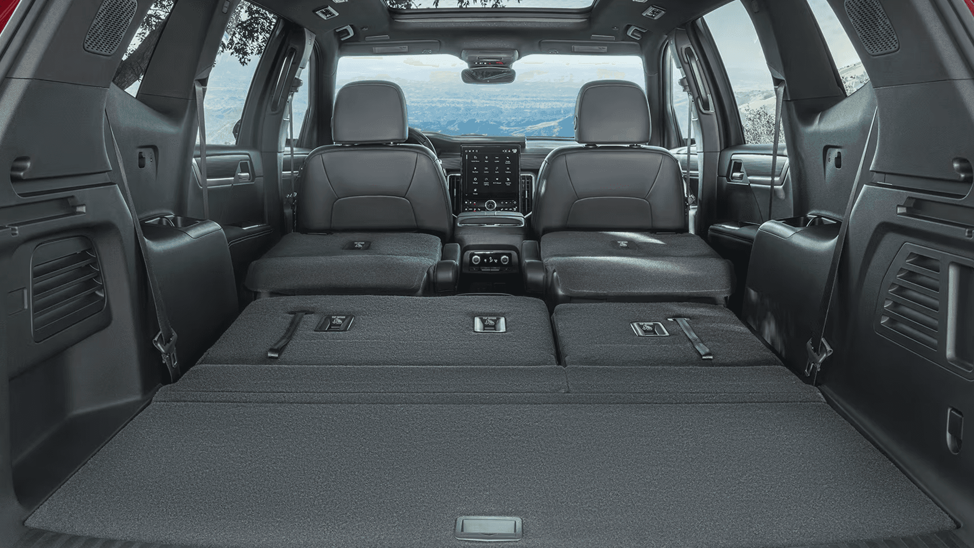 Rear cargo area of the 2026 GMC Acadia with second- and third-row seats folded flat to create a long, level load floor