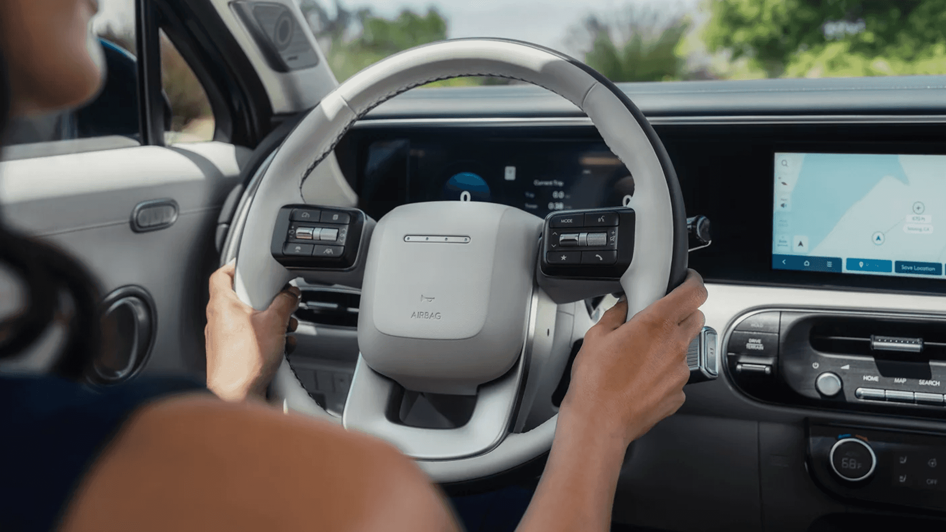 Driver focused interior view of a 2026 Hyundai Palisade showing a wide dash display area with a digital instrument cluster and a large center screen.
