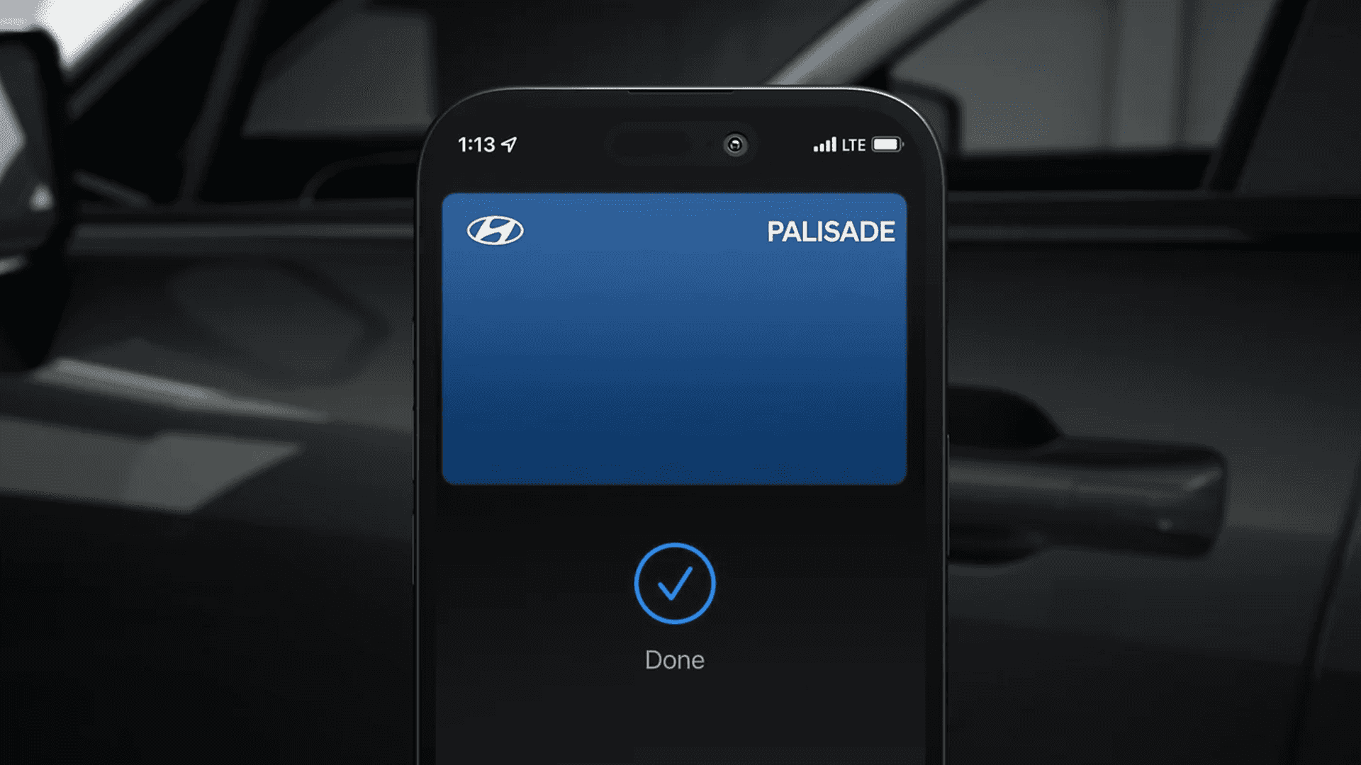 Close up of a driver hand holding a smartphone near a vehicle door handle to represent digital key access.