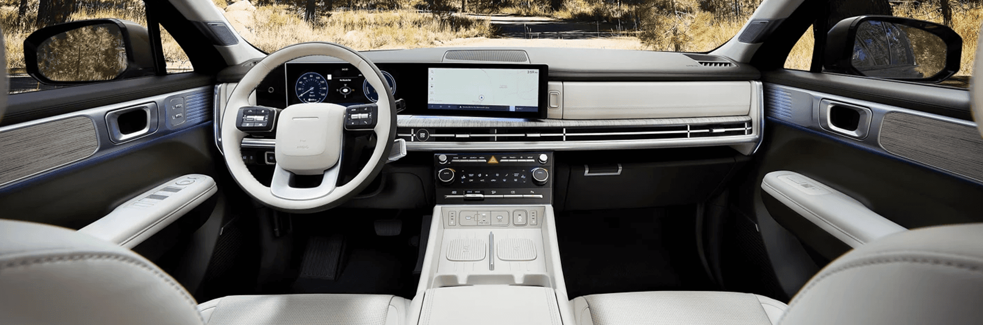 Wide front cabin view of a 2026 Hyundai Santa Fe Hybrid showing the steering wheel, digital instrument cluster, and large center touchscreen above a long horizontal dash vent.
