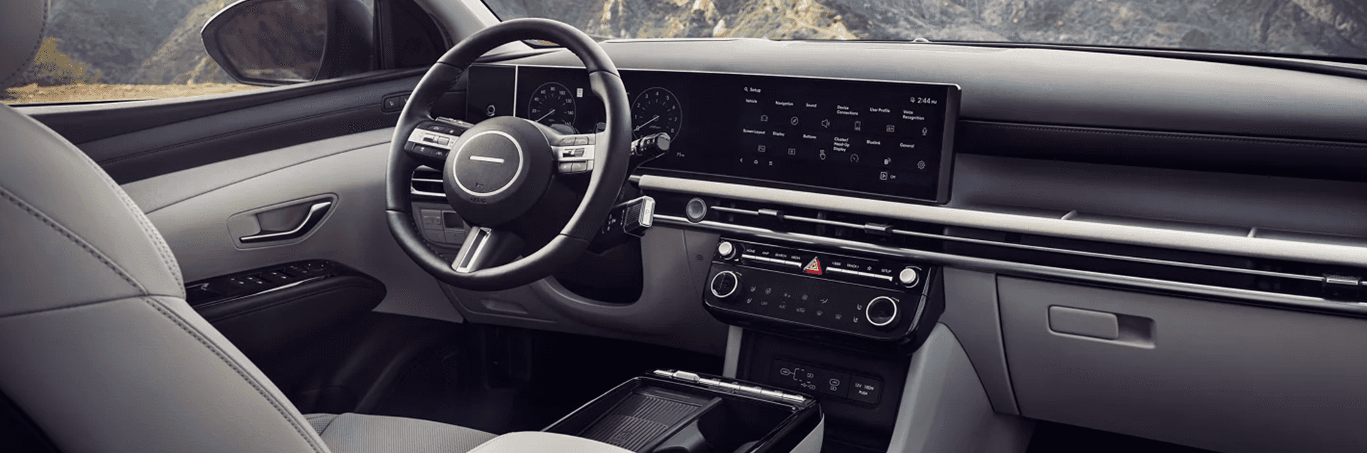 Interior view of a Hyundai Tucson dashboard with a wide digital display and center touchscreen.