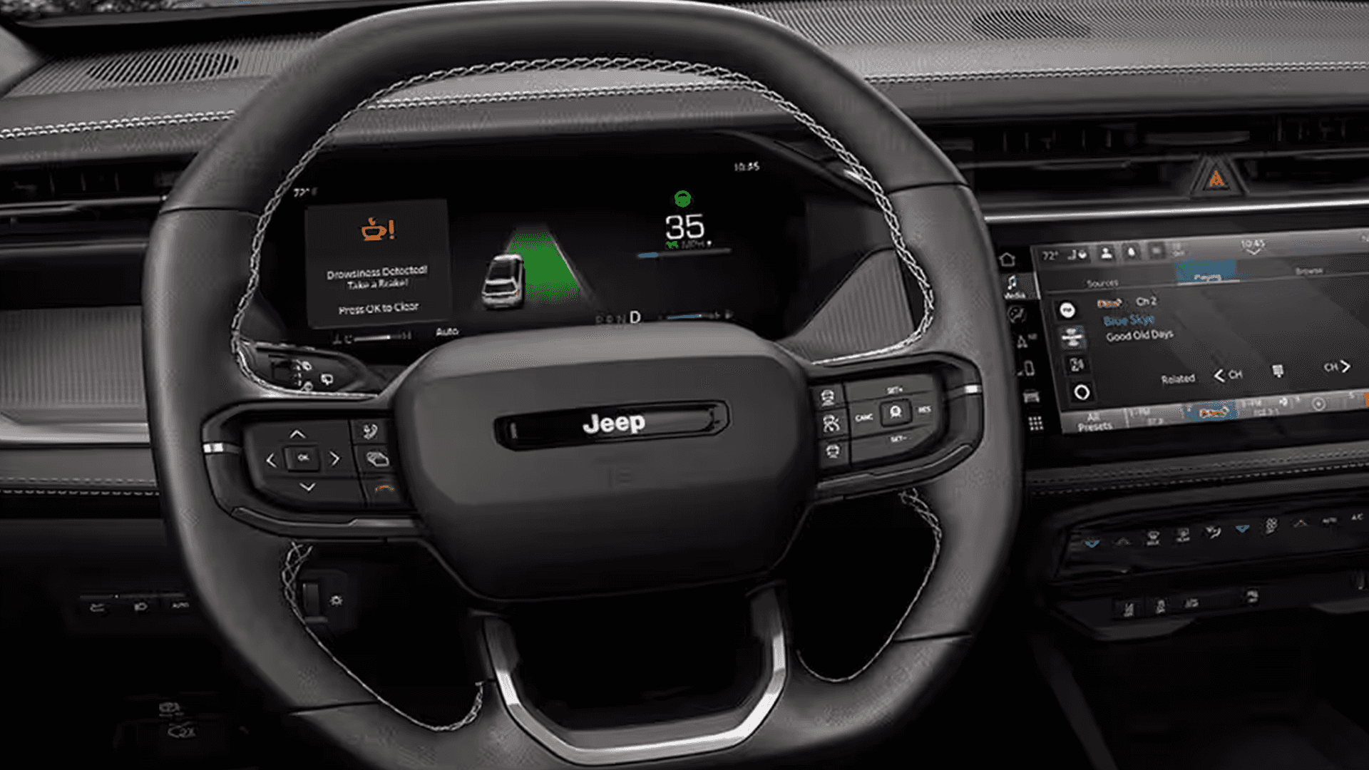 Close up of the 2026 Jeep Cherokee steering wheel and digital cluster showing a drowsy driver alert and lane guidance display.