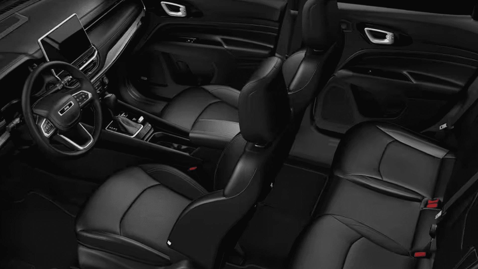 High angle view into the 2026 Jeep Compass cabin showing the front seats, rear bench, center console, and infotainment screen.