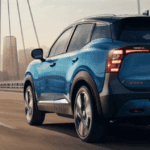 2026 Nissan Frontier driving across a modern bridge with city skyline in the background