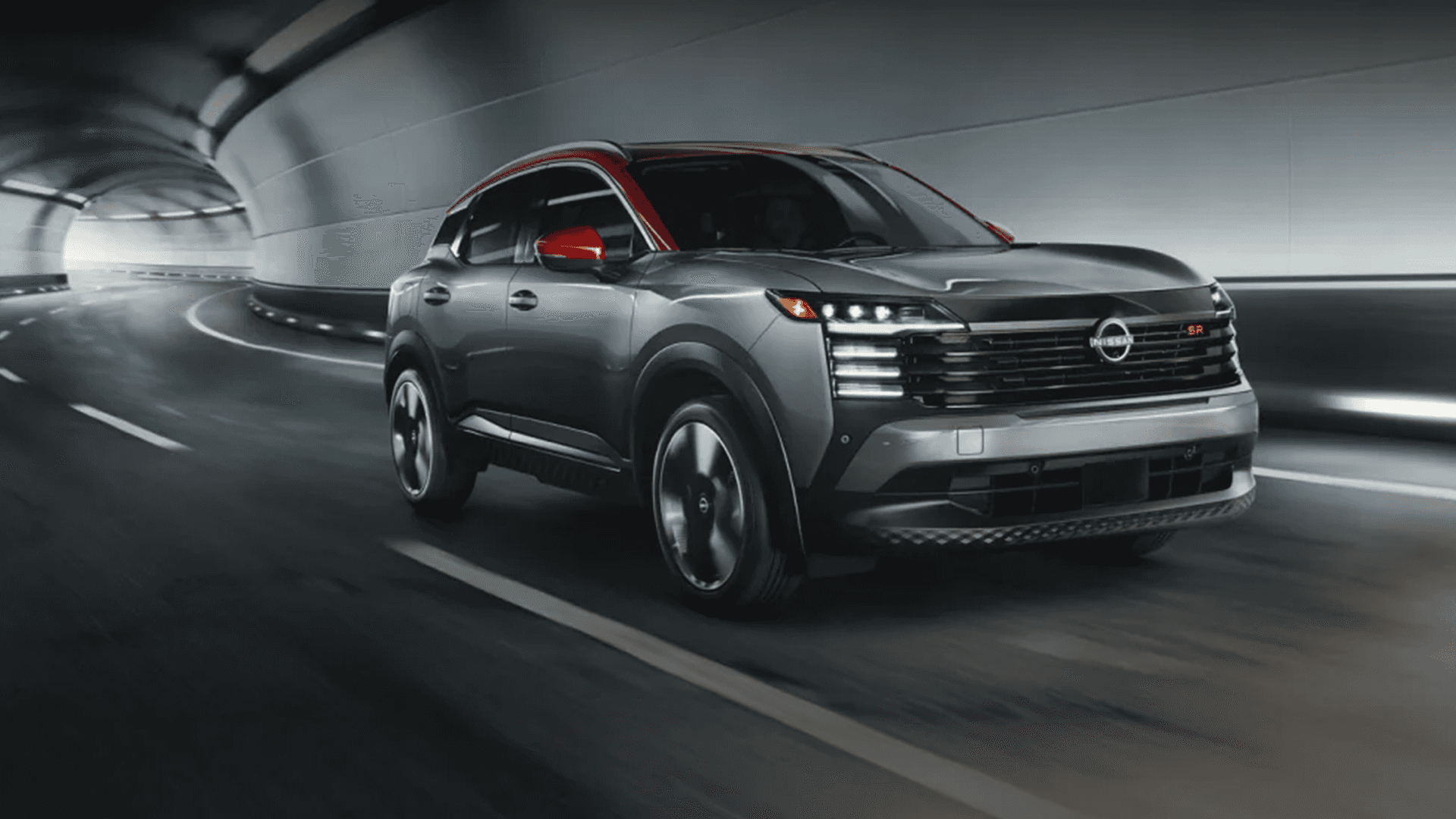 2026 Nissan Kicks driving through a tunnel with LED headlights and signature lighting