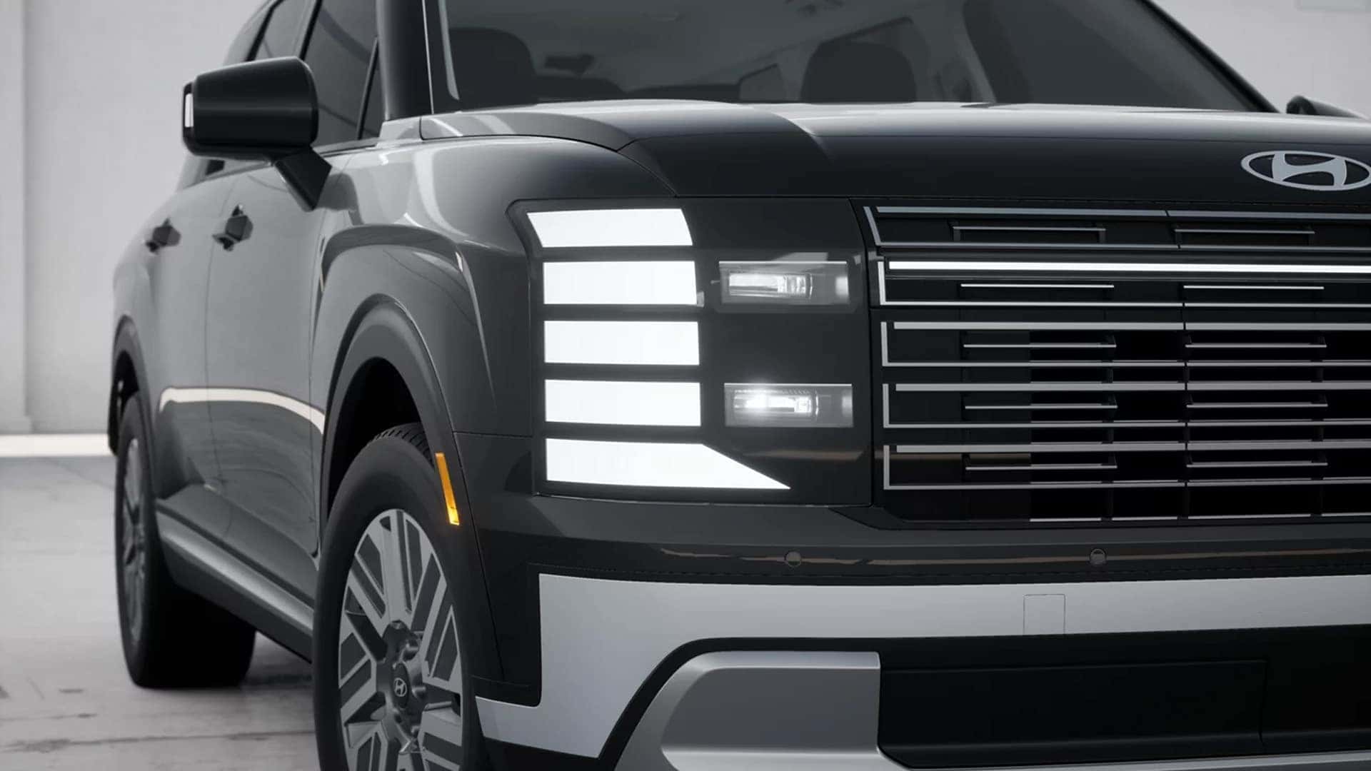 Close up of 2026 Hyundai Palisade Hybrid LED exterior lighting showing vertical daytime running lights and grille detail