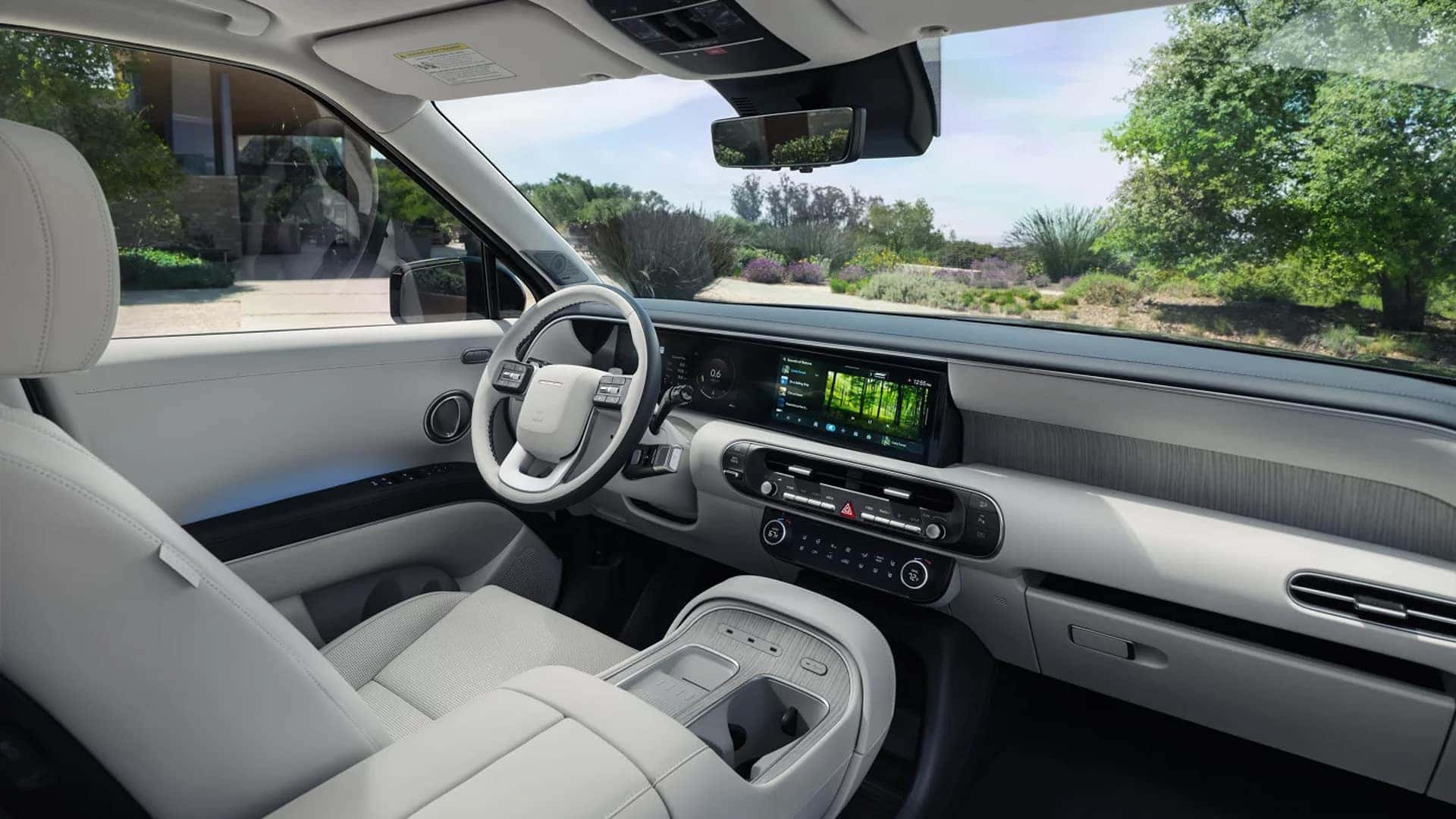 Interior of the 2026 Hyundai Palisade Hybrid featuring a wide digital dashboard, center console, and premium seating materials