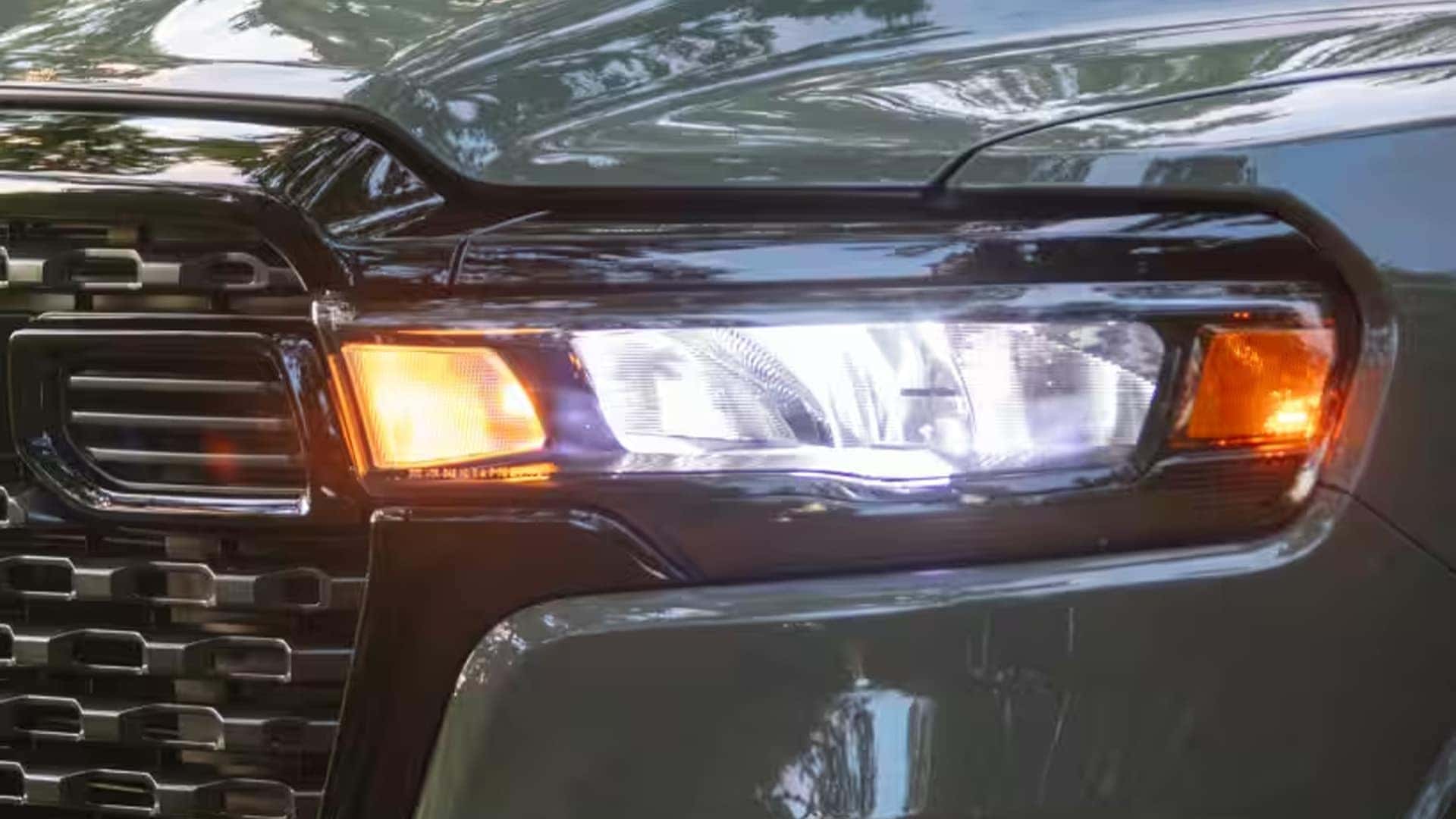 Close up of 2026 Ram 1500 LED headlamp design with illuminated daytime running lights and modern grille detail