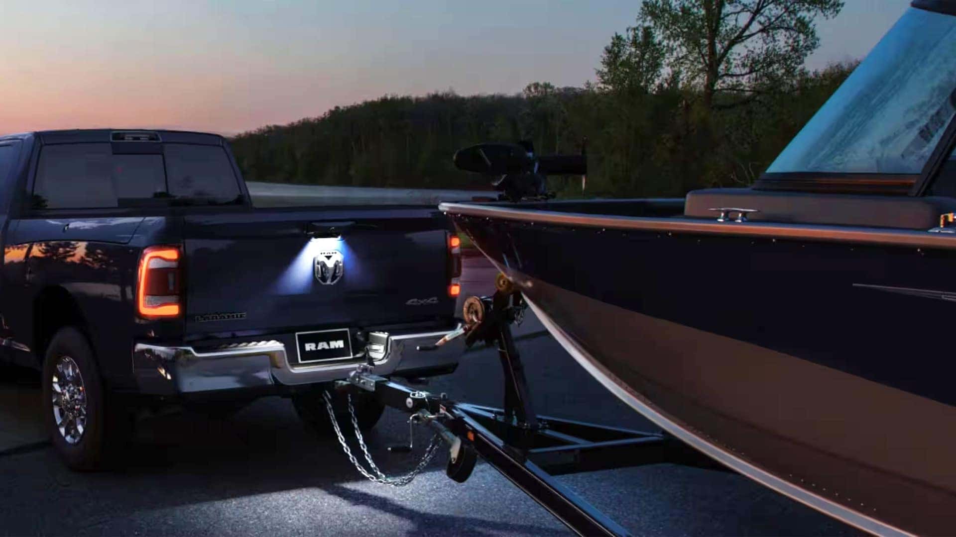 2026 Ram 1500 towing a fishing boat at sunset, highlighting engine power and towing strength
