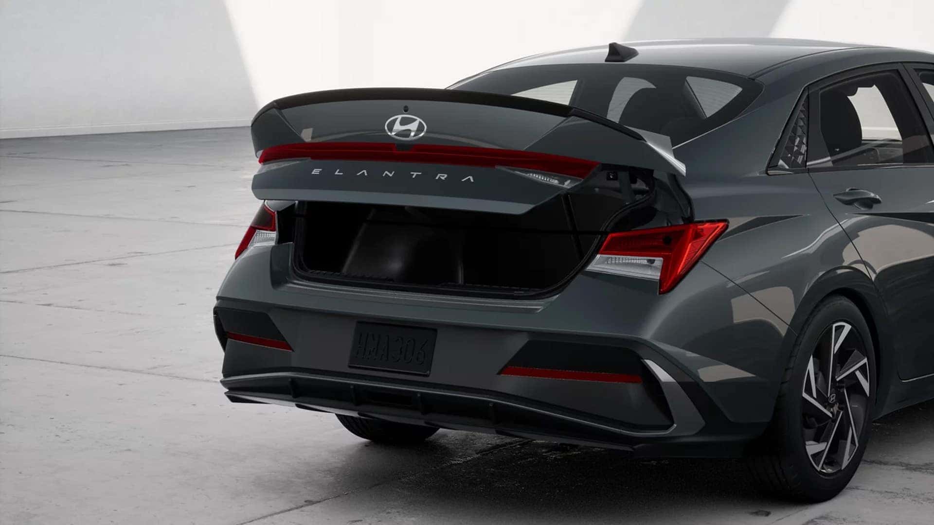Open trunk view of a 2026 Hyundai Elantra showing rear cargo space, wide trunk opening, and exterior rear styling details