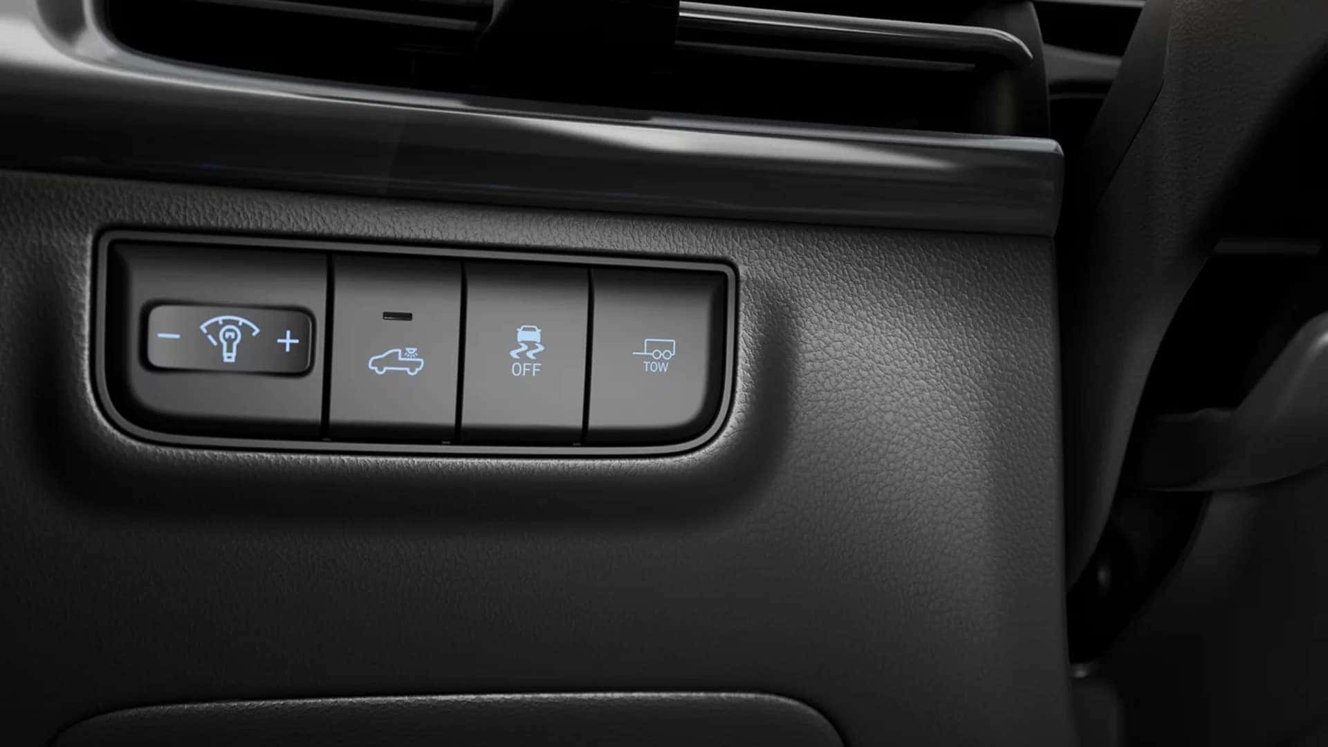 Control panel inside the 2026 Hyundai Santa Cruz showing utility related buttons for lighting, traction control, and towing support