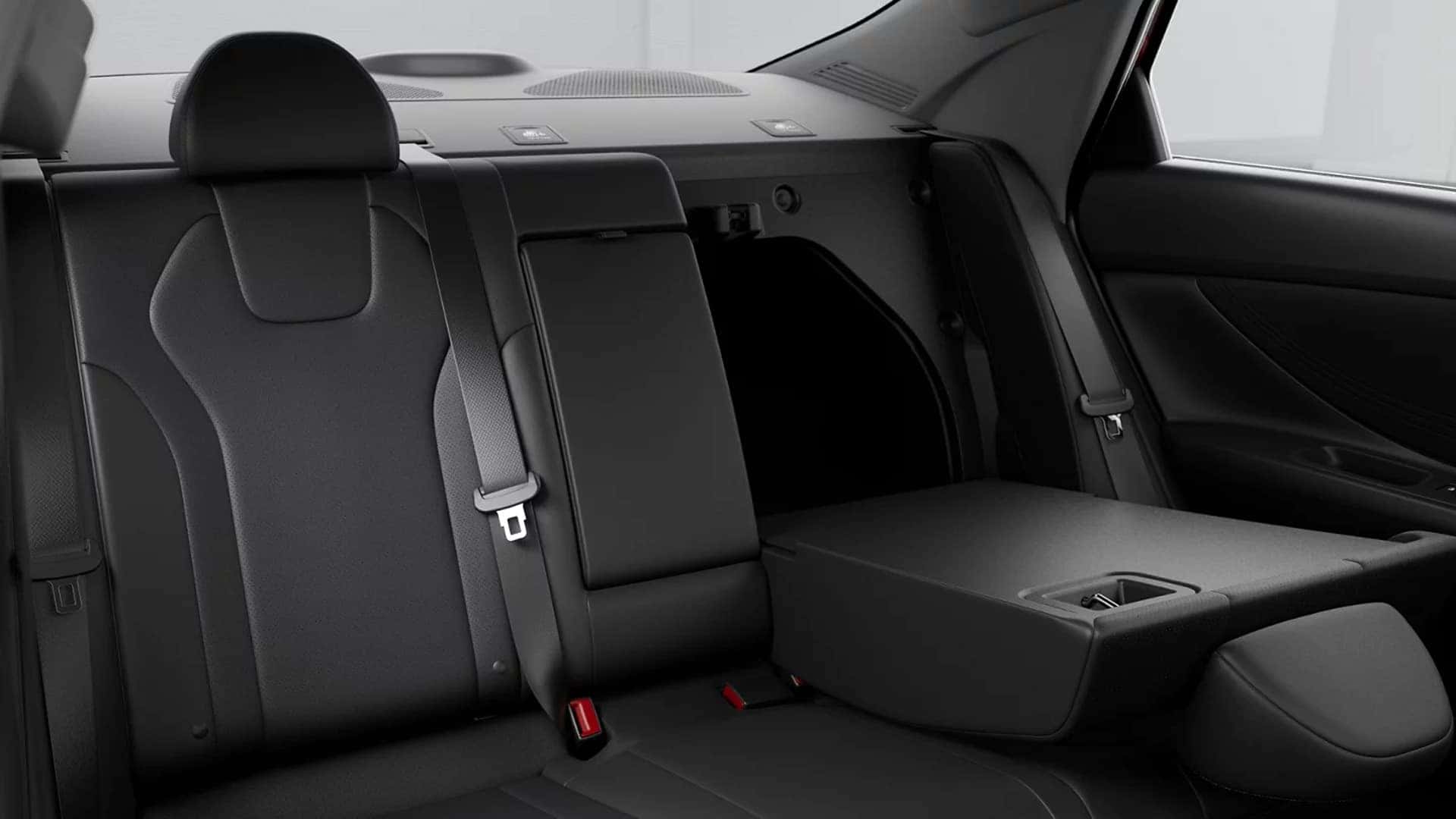 2026 Hyundai Elantra rear seat area with folding center armrest, seat belts, and rear passenger seating space