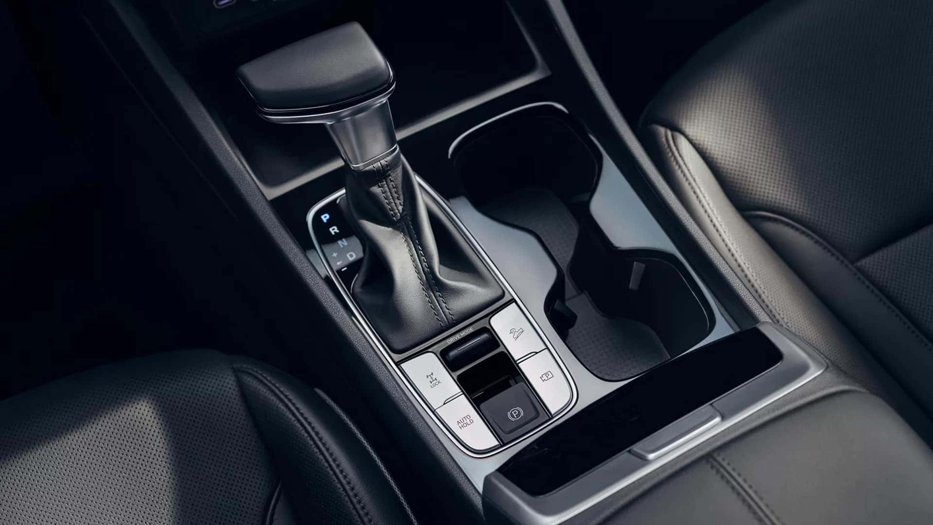 2026 Hyundai Santa Cruz center console showing gear selector, cupholders, and drive mode and traction buttons