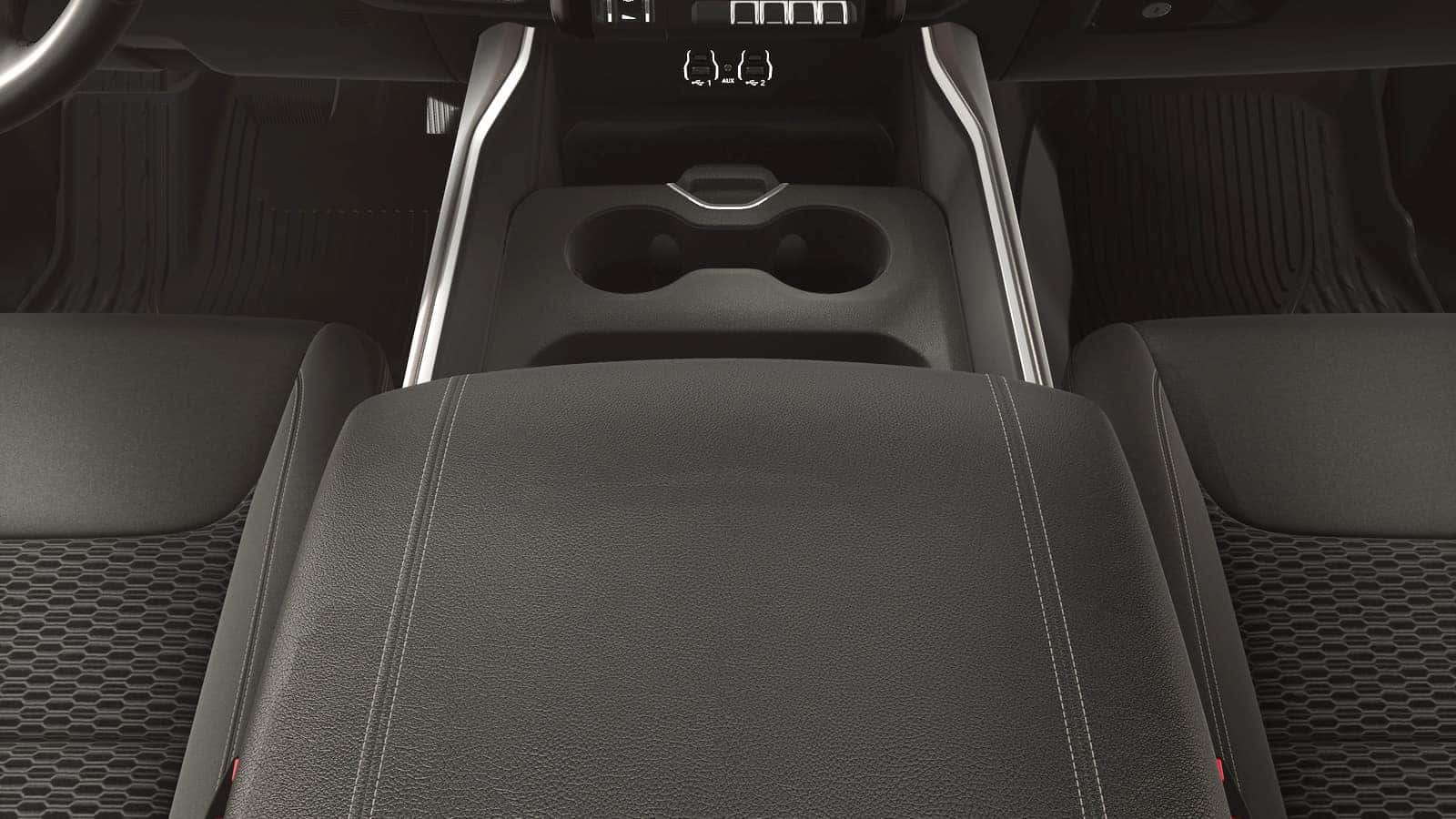 2026 Ram 1500 center console with padded armrest, dual cupholders, and organized storage between the front seats