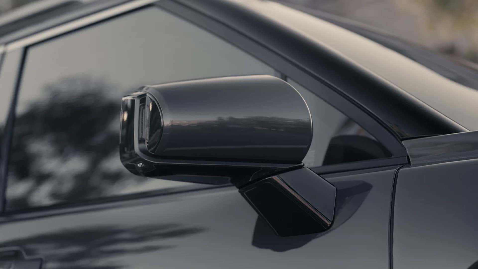 Rear view of 2026 Hyundai Palisade Hybrid driving on the road showing three row SUV proportions, wide stance, and exterior design details