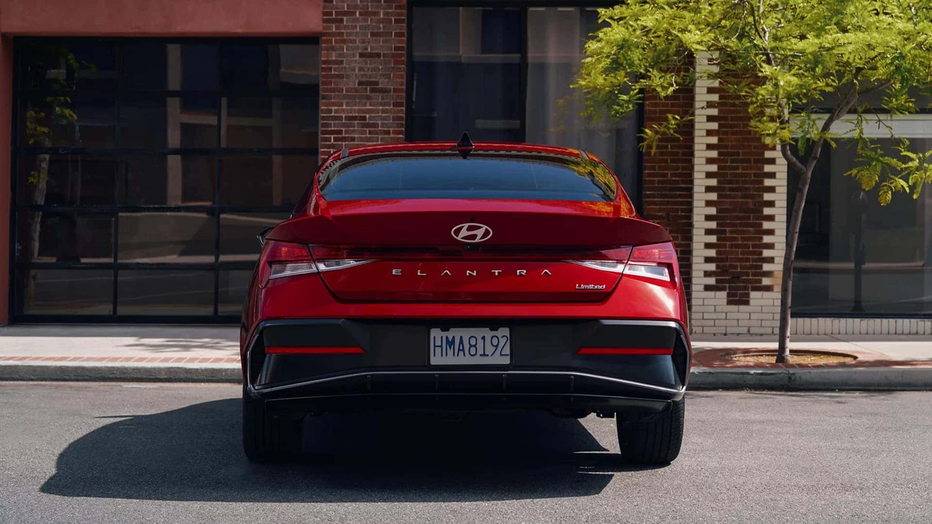 Rear view of a red 2026 Hyundai Elantra Limited highlighting rear LED taillights, trunk badging, and trim specific exterior styling