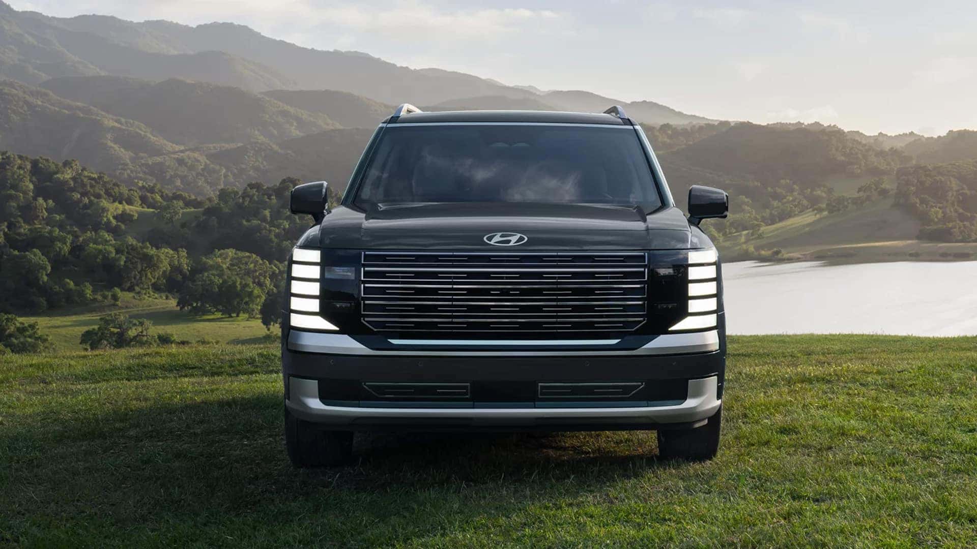 Front view of the 2026 Hyundai Palisade Hybrid parked outdoors, emphasizing its grille design, headlights, and overall proportions