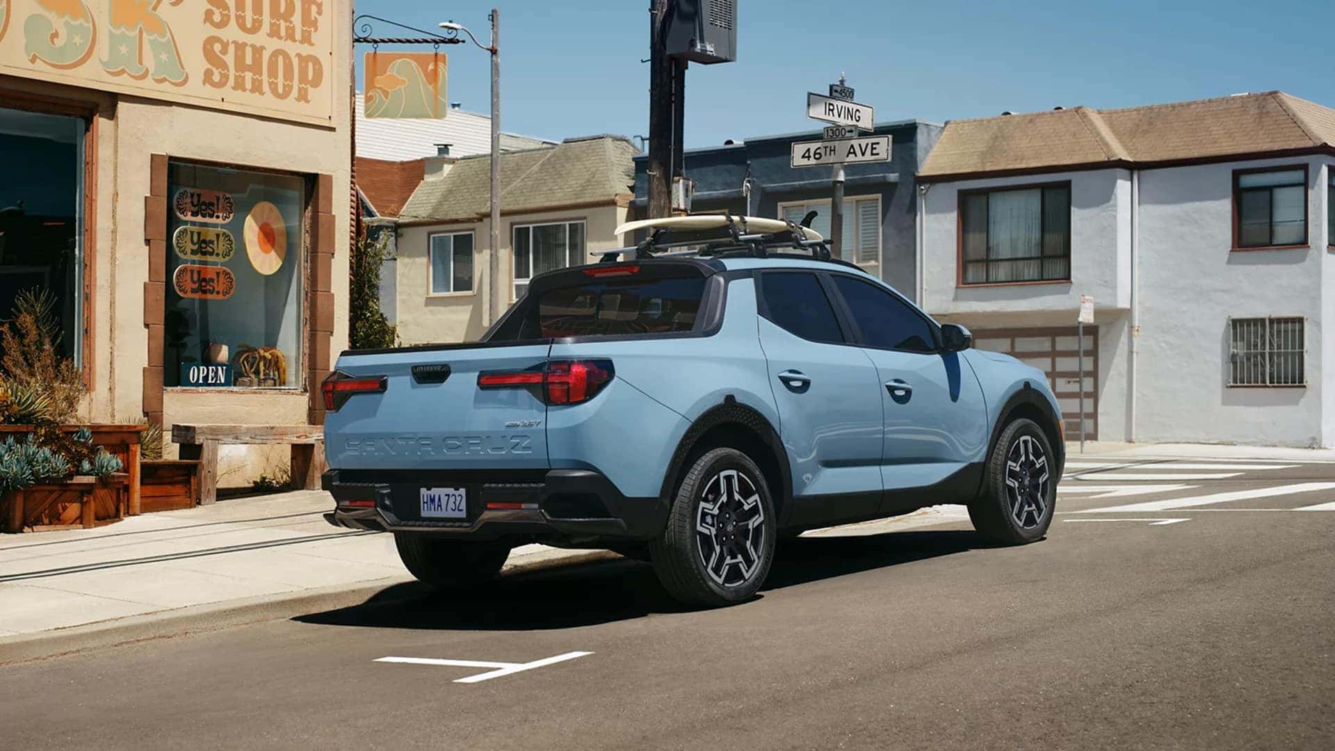 Rear three-quarter view of the 2026 Hyundai Santa Cruz parked on a city street, highlighting bed design and compact pickup stance