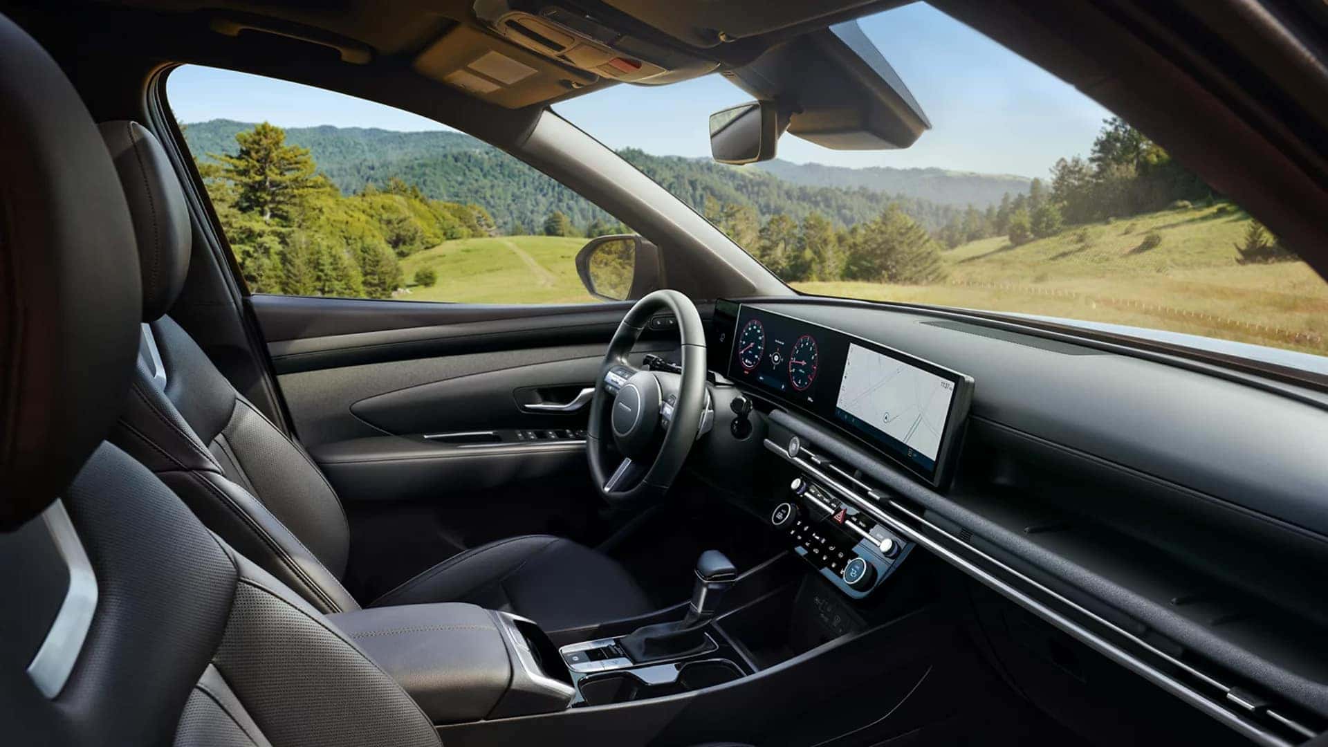 Overhead rear view of a blue 2026 Hyundai Santa Cruz on a gravel overlook with cargo loaded in the pickup bed near a lake and forest.