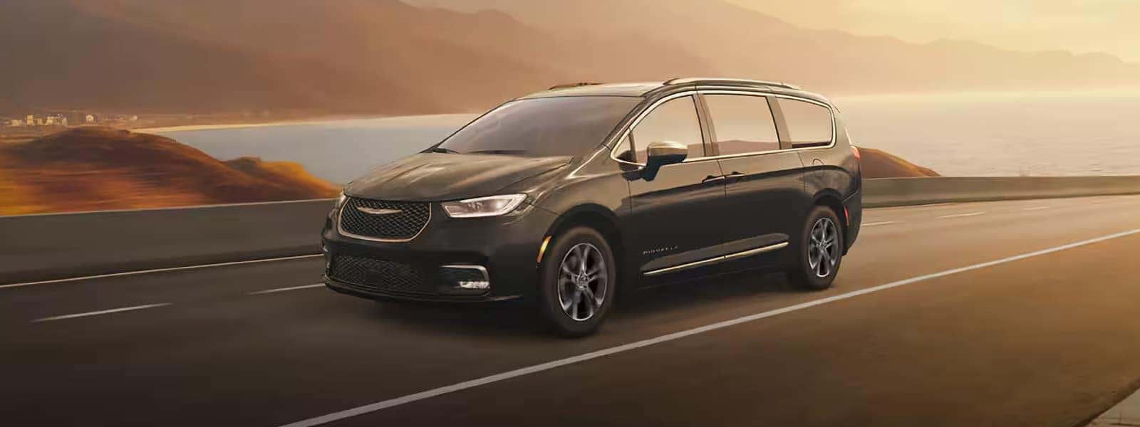2026 Chrysler Pacifica driving on a city street, front three quarter view