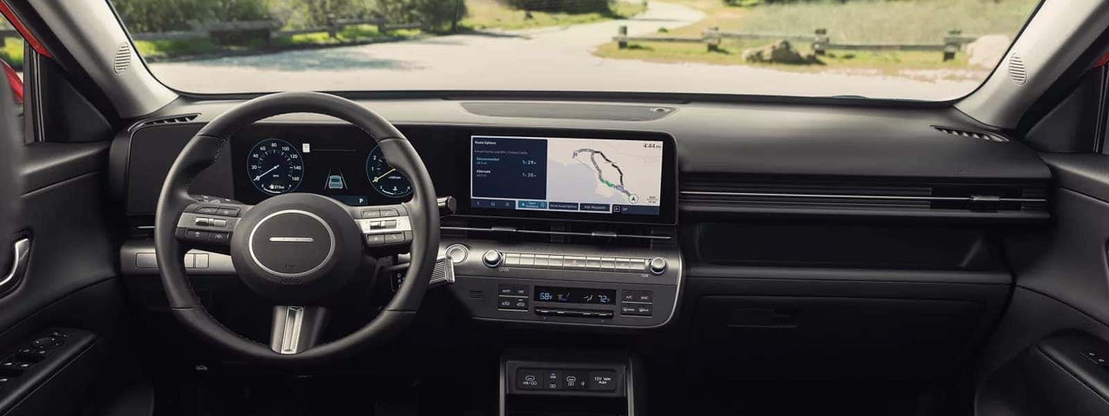Interior view of the 2026 Hyundai Kona showcasing the digital gauge cluster, wide center touchscreen, steering wheel controls, and clean dashboard layout