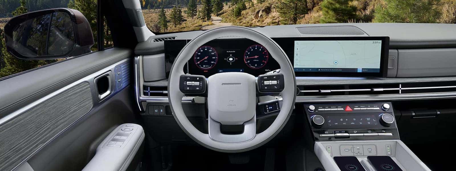 Interior view of the 2026 Hyundai Santa Fe showing the wide digital display panel, steering wheel controls, and modern dashboard layout