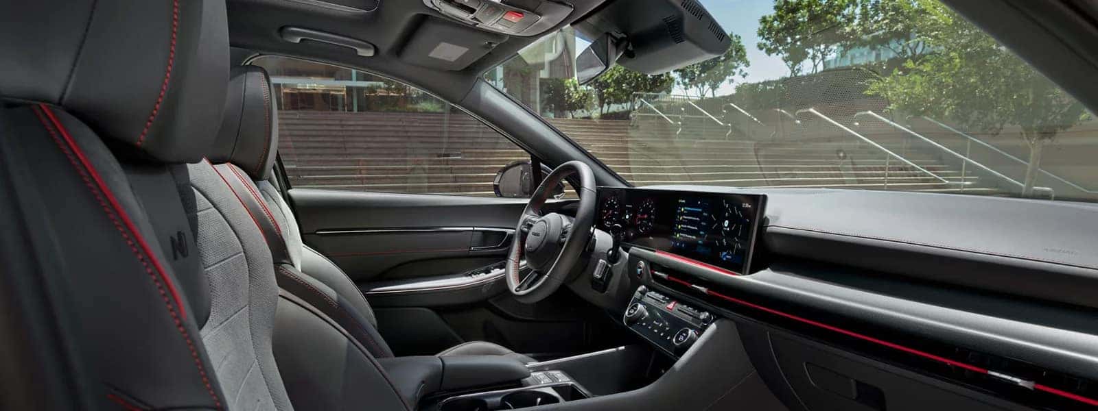 Front interior view of the 2026 Hyundai Sonata showing the dashboard layout, digital display screens, sport seats with red stitching, and center console design.