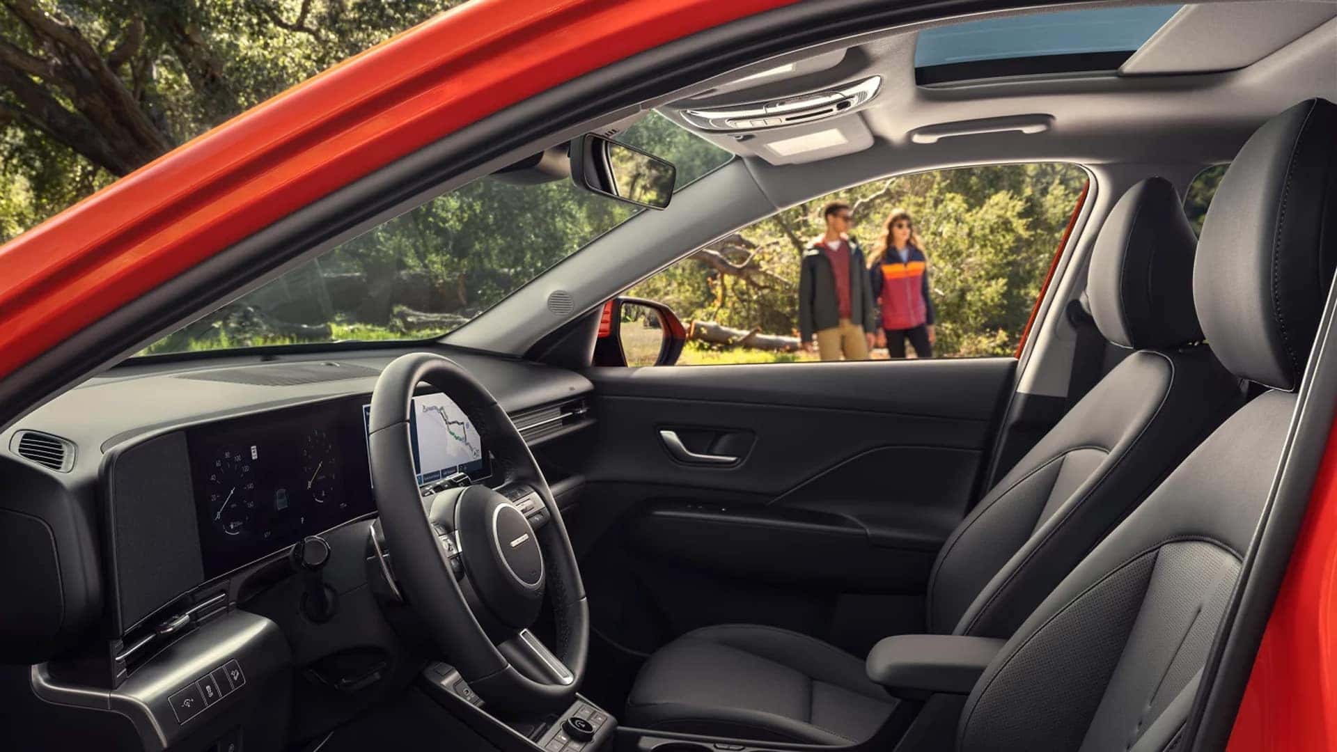 Driver view of the 2026 Hyundai Kona interior with steering wheel, digital displays, dashboard layout, and sunroof above