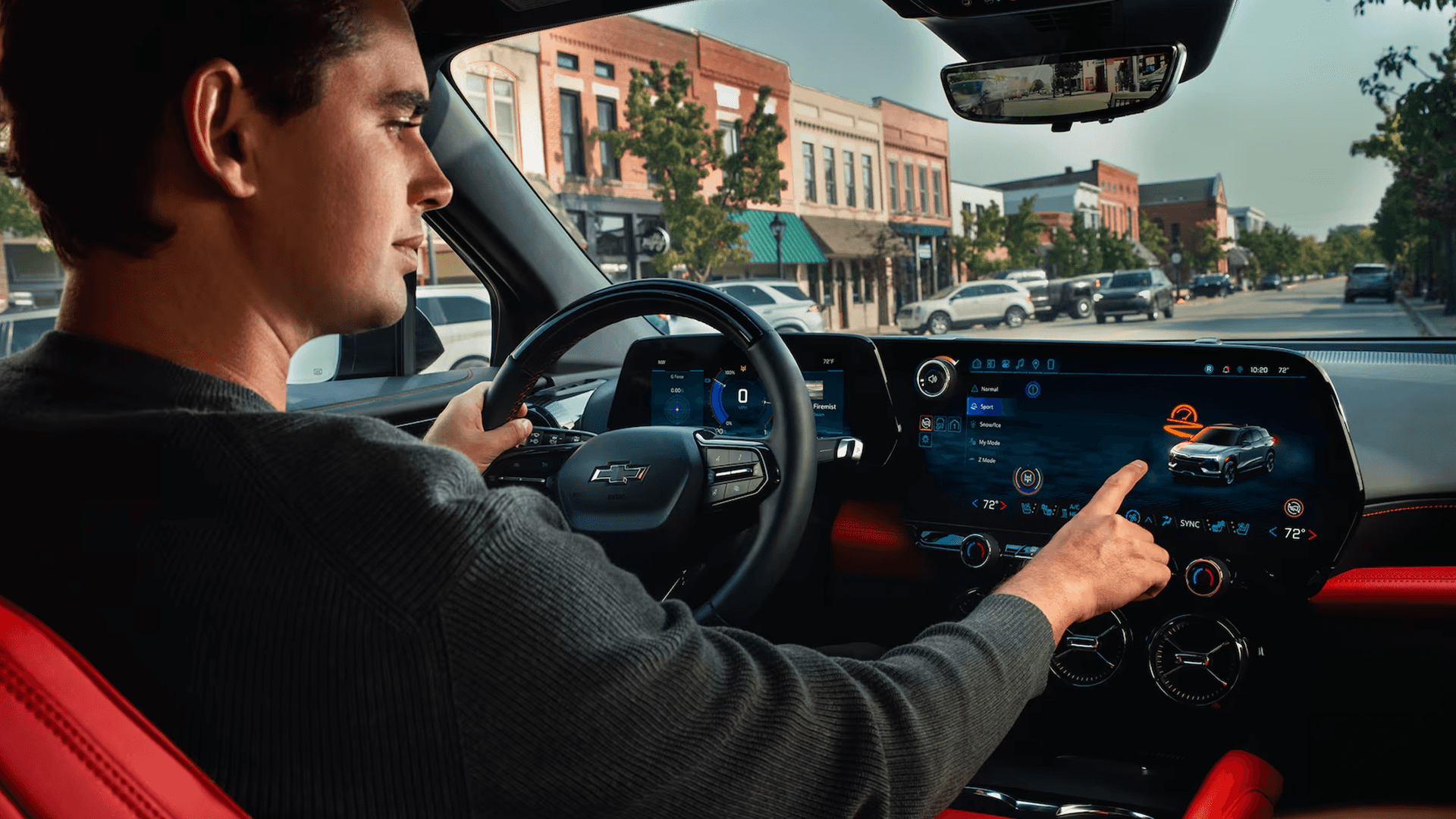 Driver perspective inside the 2026 Chevy Blazer EV with digital gauge cluster, center display, and red interior accents