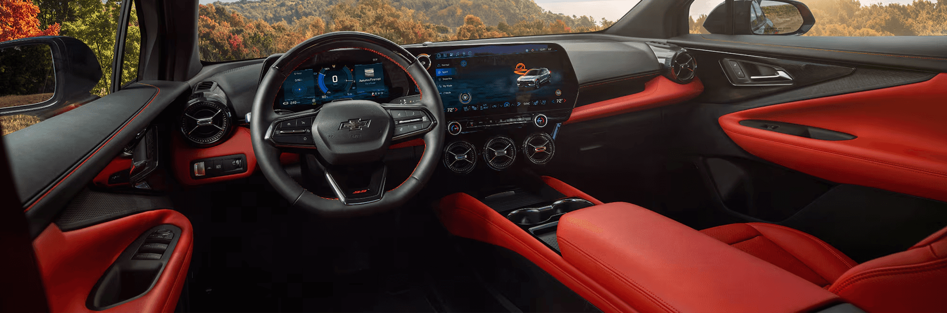 Wide interior view of the 2026 Chevy Blazer EV featuring red-accent seats, digital displays, and driver cockpit layout