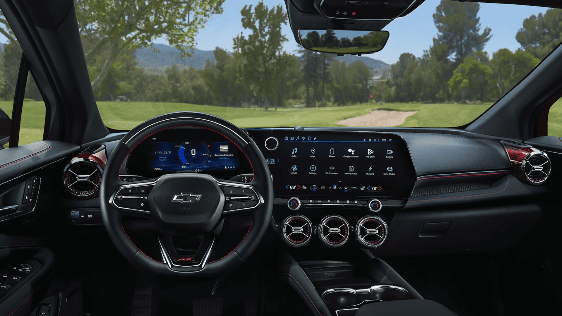 Wide Blazer EV cockpit view showing digital driver cluster and center touchscreen with trees outside windshield