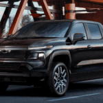 Black 2026 Chevy Silverado EV parked outside a modern building, front three quarter view in city setting